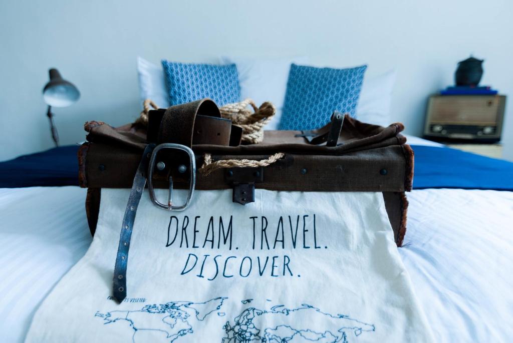 una valigia su un letto con le parole "sogno viaggio scoperto" di BE41 Boutique Hotel a Maastricht