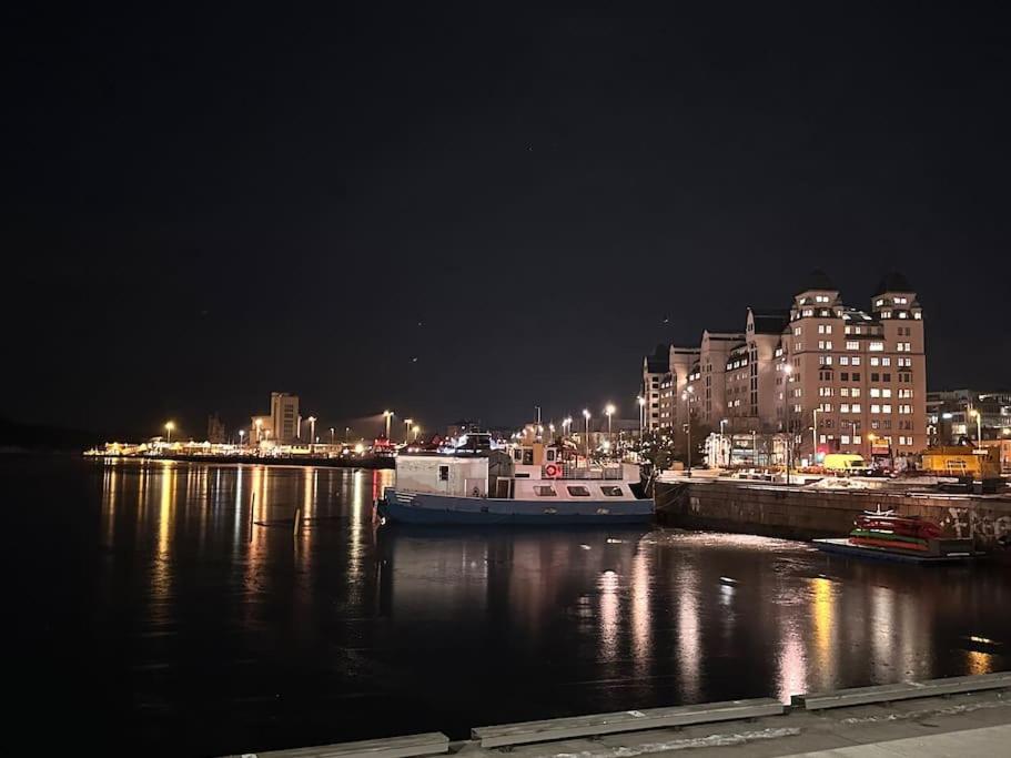 a boat is docked in a harbor at night at Cozy apartment by Opera house in Oslo