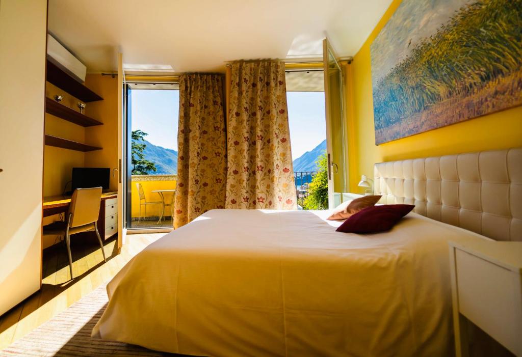 a bedroom with a large bed with a large window at Montebello Lake in Lecco