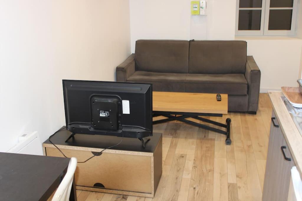 een woonkamer met een bank en een tv op een doos bij Studio cosy et chaleureux in Royat