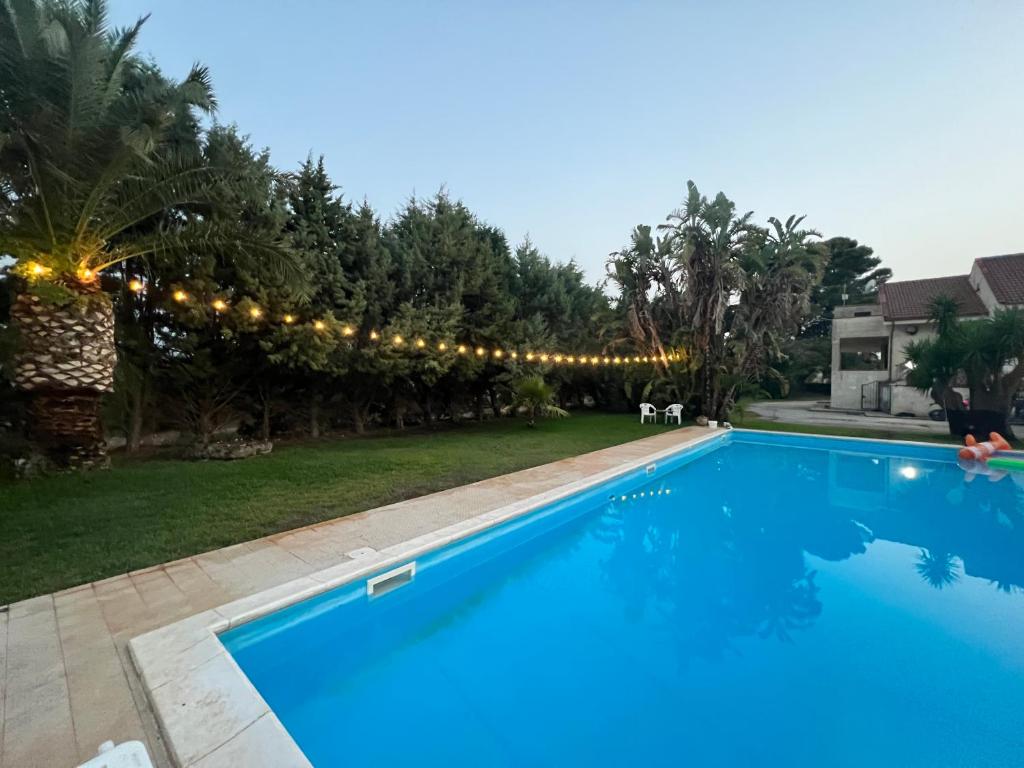 une grande piscine bleue avec une chaîne de lumières dans l'établissement PROJEKT X, à Villasmundo