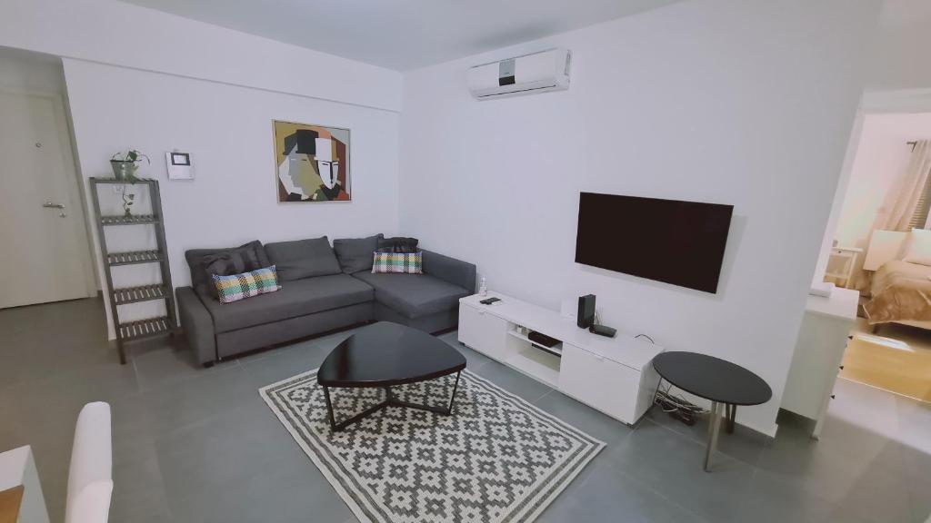 a living room with a couch and a tv at STAY Tranquil Terrace in Aglantzia