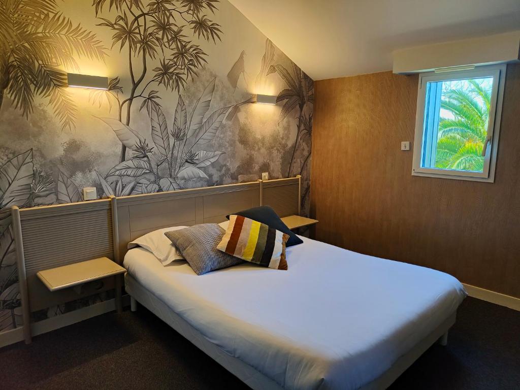 a bedroom with a large bed with a mural on the wall at Domaine de la Barbinais in Saint Malo