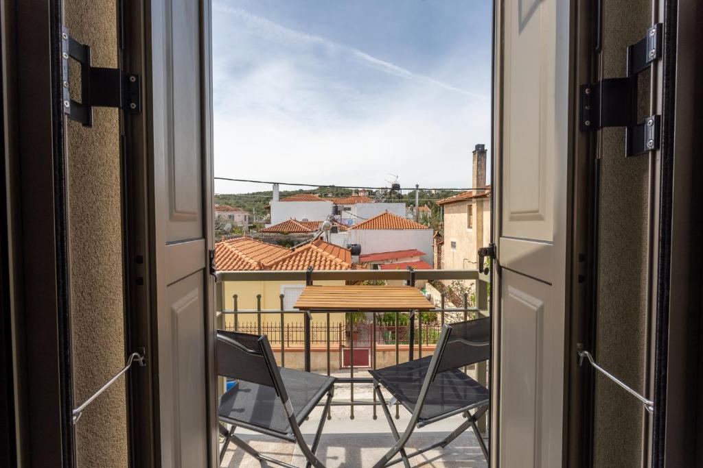 una vista dalla porta di un balcone con tavolo e sedie di Akti Vigla Apartments a Mytilini