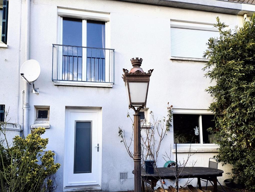 a street light in front of a white building at Maison de 5 chambres avec jardin clos et wifi a Maurepas in Maurepas