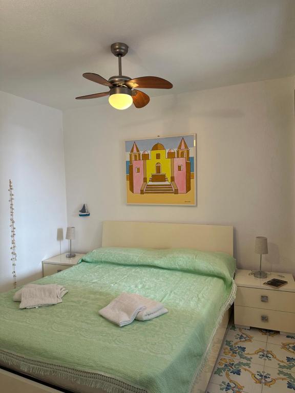 a bedroom with a bed with a ceiling fan at LA BOMBONIERA in Ischia