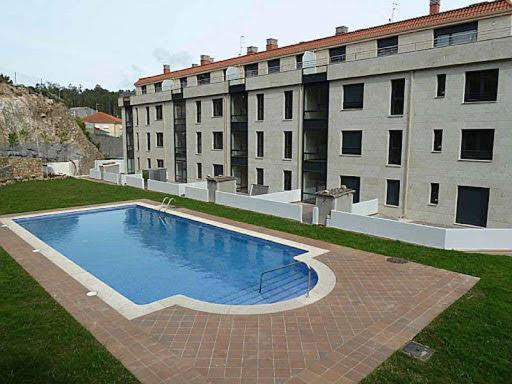 una gran piscina frente a un edificio en Playa y piscina a tu alcance en boiro, en Boiro