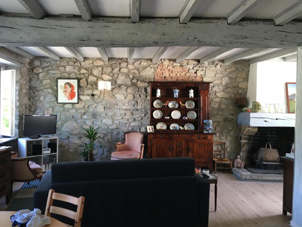 un salon avec un canapé et un mur en pierre dans l'établissement Appartement Duplex dans vieille maison Basque, à Urrugne
