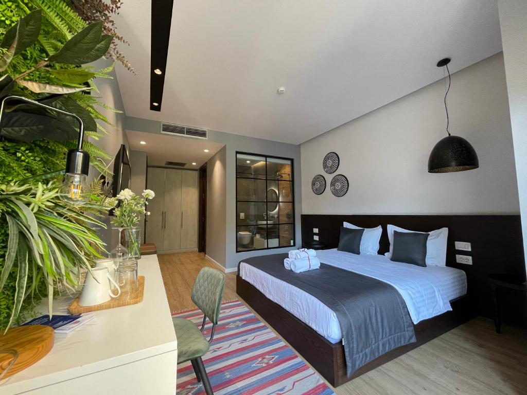 pokój hotelowy z łóżkiem i rośliną w obiekcie Retreat Apartments w Tiranie