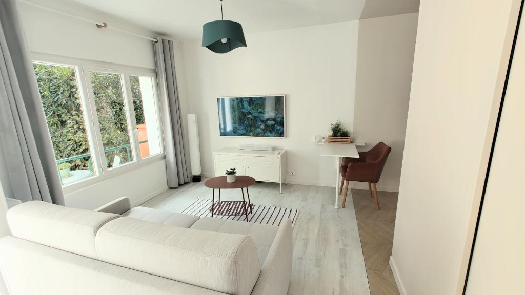 un salon blanc avec un canapé blanc et une table dans l'établissement Studio avec jardin entre Paris Versailles et gares, à Chaville