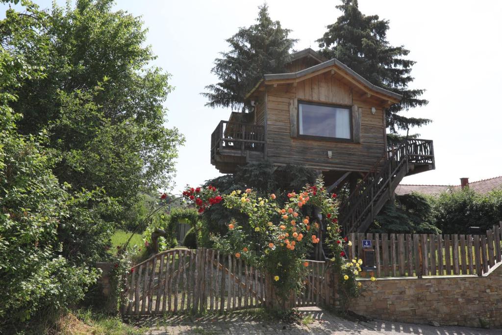 una casa en el árbol con balcón en una valla en Baumhaus, en Imbach