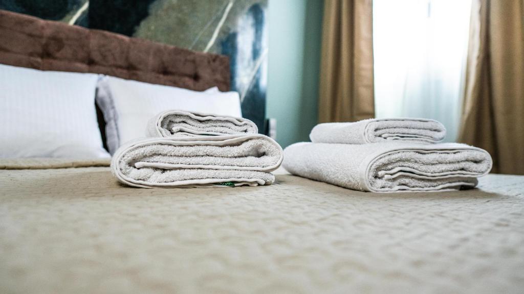 una pila de toallas sentadas encima de una cama en Rooms Batalogianni, en Kalambaka