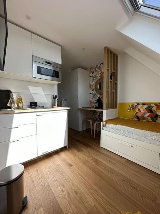 een kamer met een keuken en een bed in een kamer bij Studette entièrement rénovée et lumineuse in Caen
