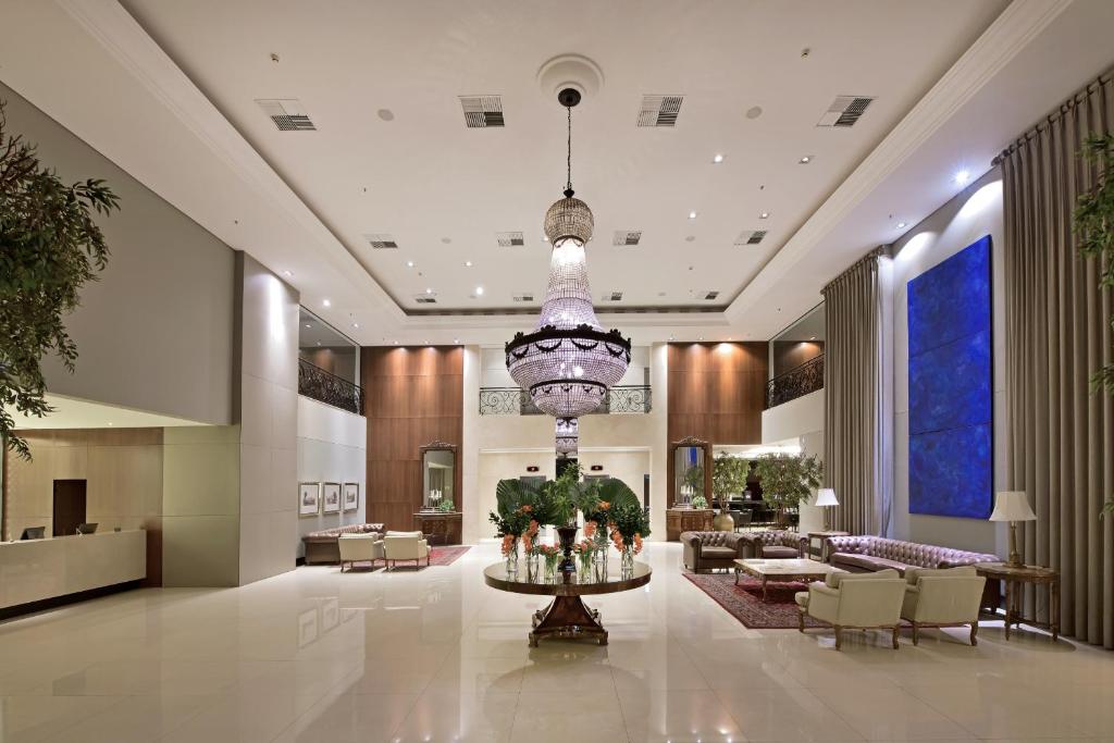 a lobby of a hotel with a chandelier at Hotel Mont Blanc Premium in Ribeirão Preto