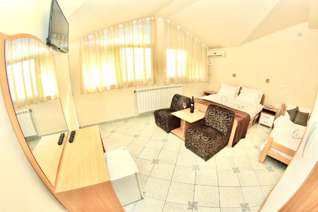 - un salon avec un lit, une table et des chaises dans l'établissement Hotel Lagadin, à Ohrid