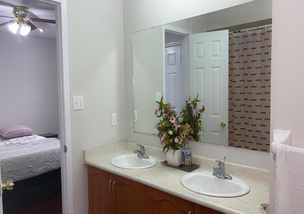 a bathroom with two sinks and a large mirror at Beautiful private Room near Airport in Brampton