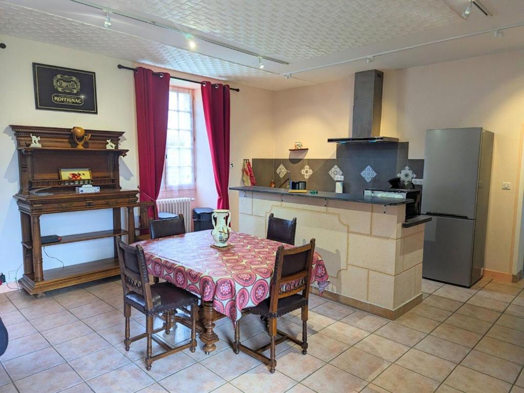 a kitchen with a table with chairs and a stove at Gîte Cherves-Richemont, 3 pièces, 5 personnes - FR-1-653-205 in Cherves-de-Cognac