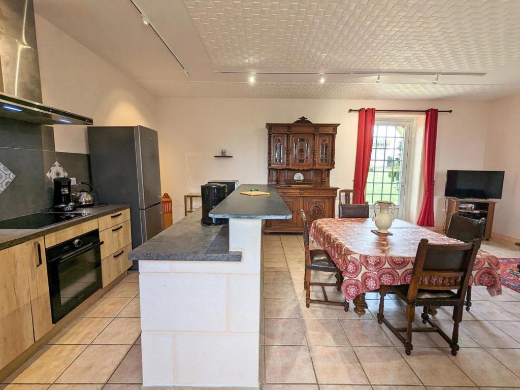 a kitchen with a table and a dining room at Gîte Cherves-Richemont, 3 pièces, 5 personnes - FR-1-653-205 in Cherves-de-Cognac