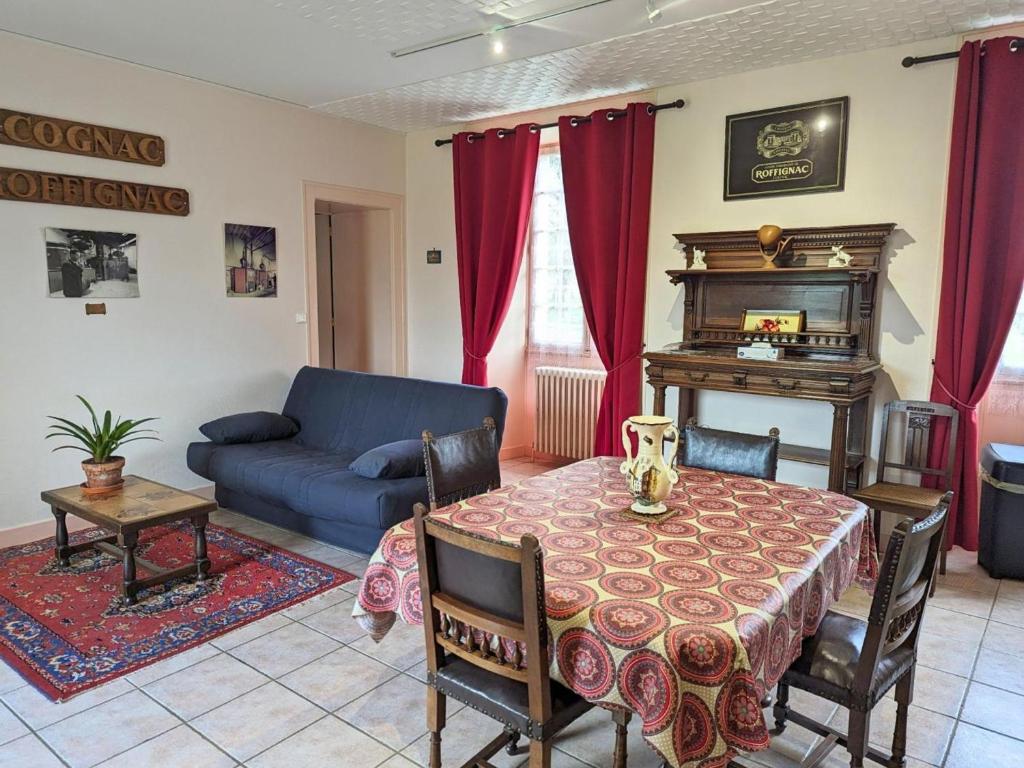 a living room with a table and a couch at Gîte Cherves-Richemont, 3 pièces, 5 personnes - FR-1-653-205 in Cherves-de-Cognac