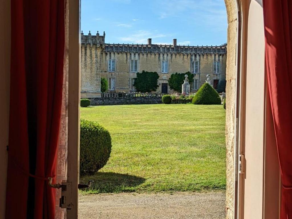 an open door to a yard with a castle at Gîte Cherves-Richemont, 3 pièces, 5 personnes - FR-1-653-205 in Cherves-de-Cognac