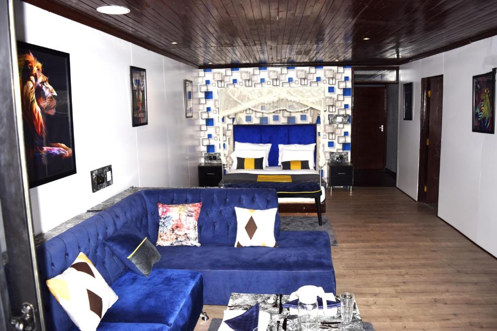 sala de estar con sofá azul y cama en Kitumo Mara Lodges, en Mara Simba
