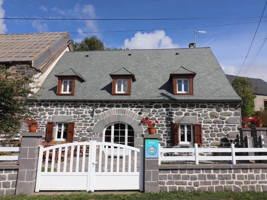 a stone house with a white fence in front of it at Gîte Paulhac, 5 pièces, 11 personnes - FR-1-742-80 in Paulhac