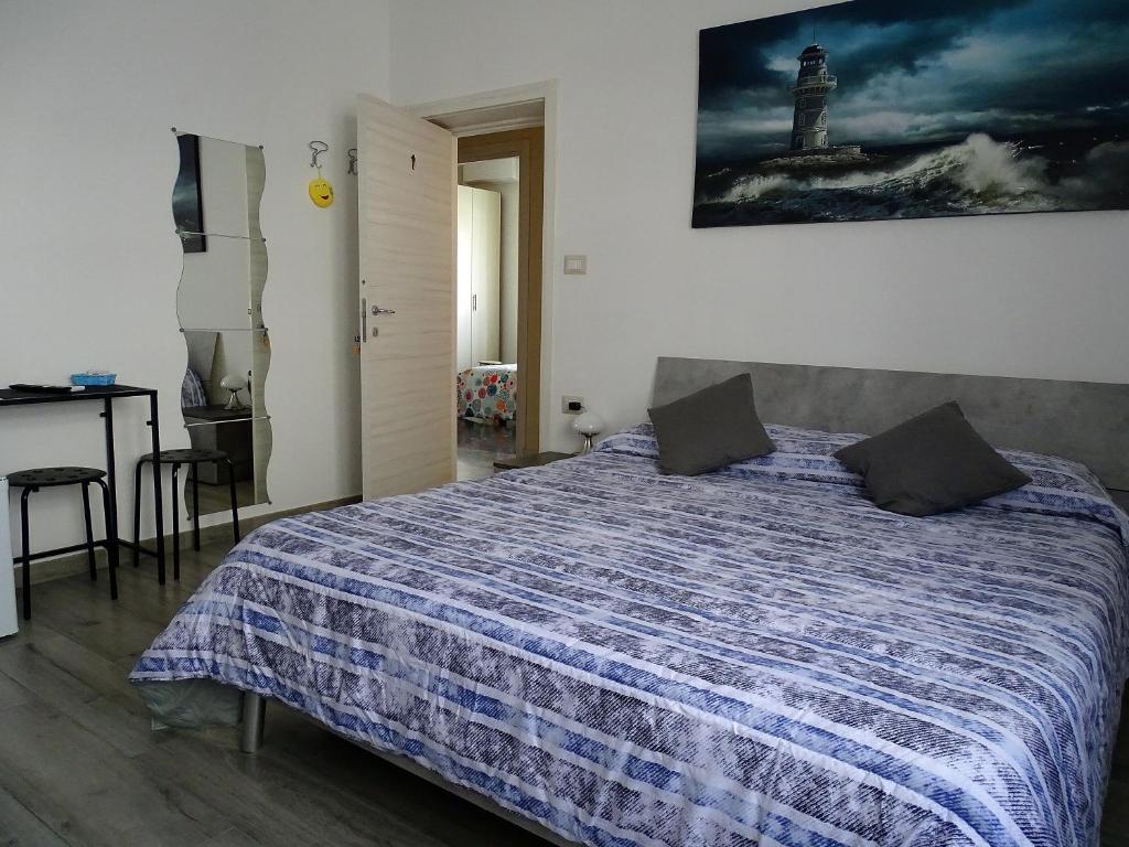 a bedroom with a bed and a lighthouse on the wall at Affittacamere SS. Smile in Loreto