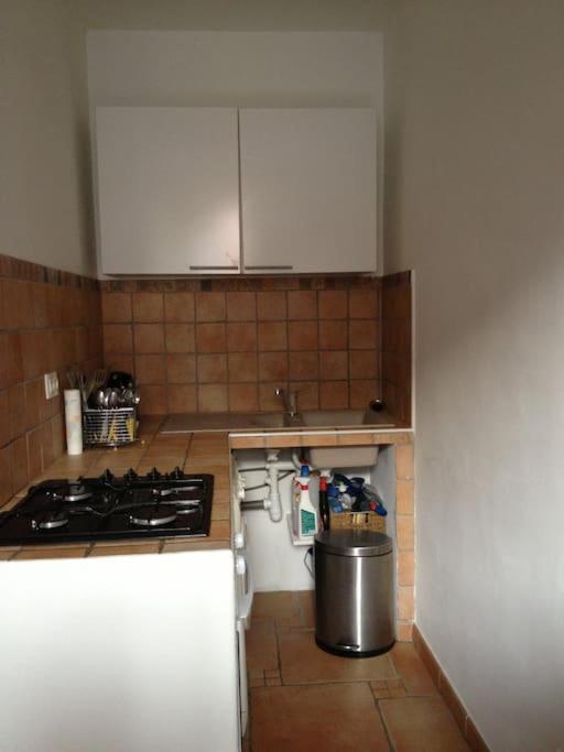 une cuisine avec une cuisinière et une poubelle dans l'établissement Location studio place du marché 4eme étage, à Bastia