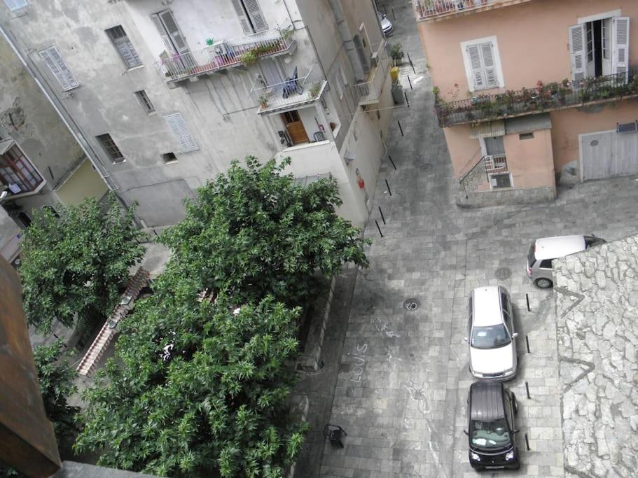 una vista aérea de los coches estacionados en un patio con edificios en Location studio place du marché, en Bastia