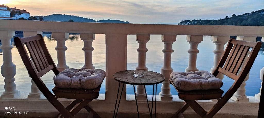 two chairs and a table on a balcony overlooking the water at Adio Mare~Soba~ in Pomena