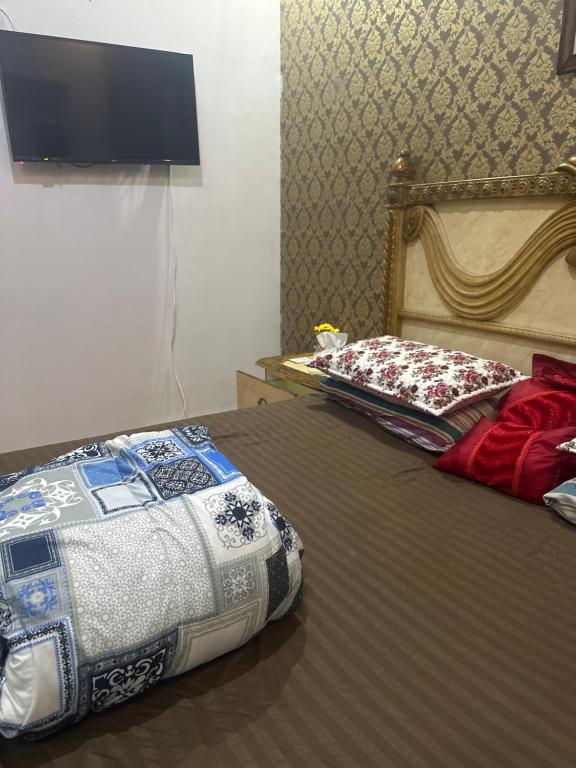a bedroom with two beds and a flat screen tv at غرفه وحمام مشترك داخل شقه مشتركه للرجال فقط Single room and shared bathroom 2 Jeddah Corniche in Jeddah