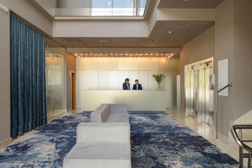 two people standing in the lobby of a building at Hotel Antik San Sebastián in Donostia-San Sebastián