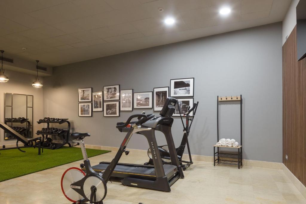 a gym with exercise bikes and pictures on the wall at Hotel Antik San Sebastián in Donostia-San Sebastián