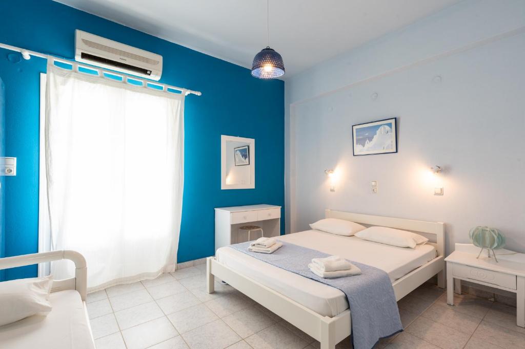 a bedroom with a bed and a blue wall at Galini me thea in Chrissi Akti