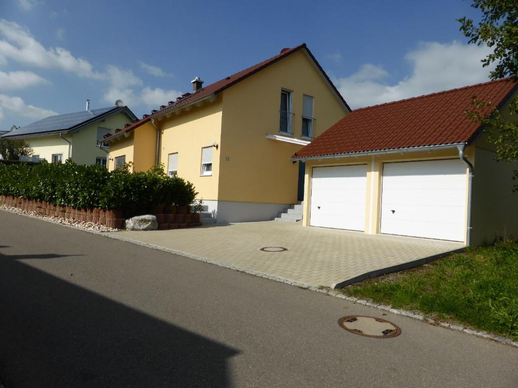 a house with two white garage doors on a street at Ferienhaus Alina in Salem