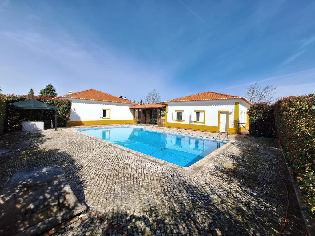 a swimming pool in front of a house at Quinta São José in Coruche