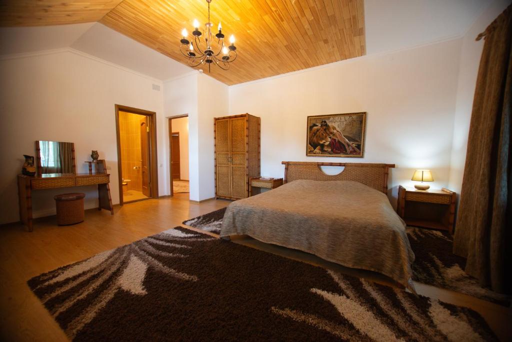 - une chambre avec un grand lit et un plafond en bois dans l'établissement "Alatau" Гостевой Дом, à Chtchoutchinsk