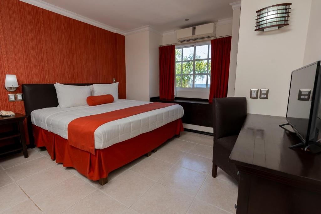 a bedroom with a bed and a flat screen tv at Hotel Ocean View in Campeche
