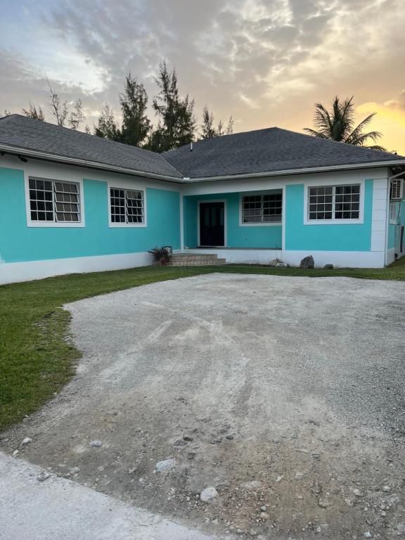 a home with a blue house at Krizia Place in Nassau