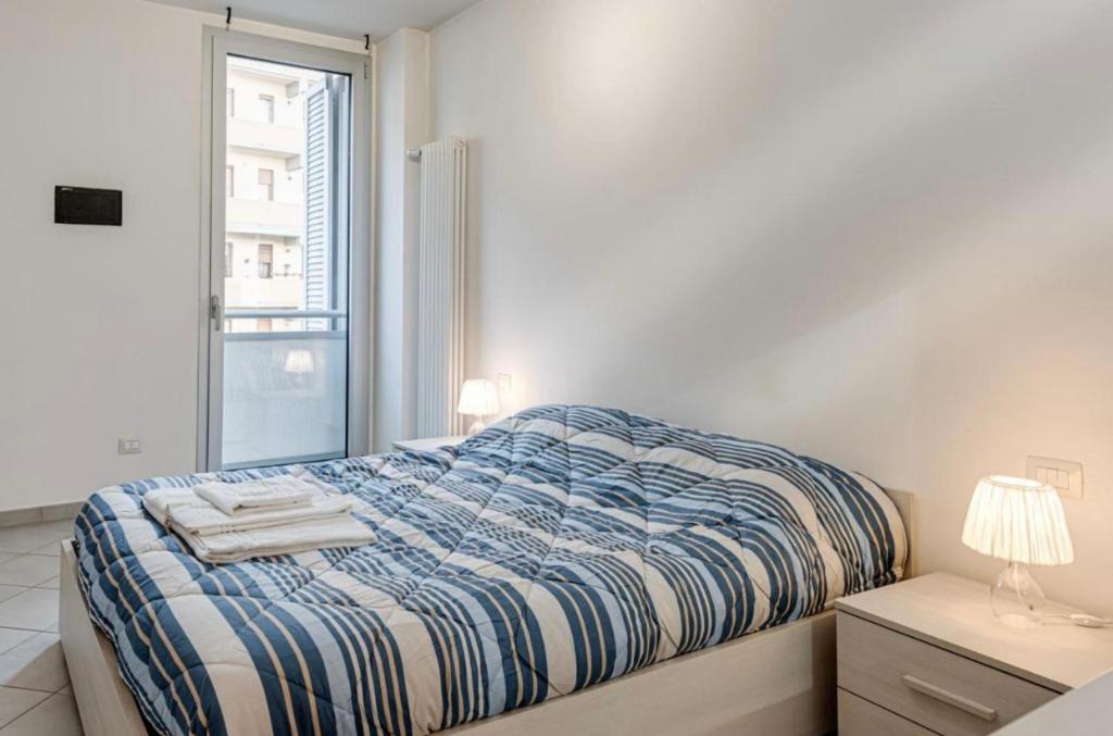 a white bedroom with a bed and a window at Comfort Scandicci Centro Facile accesso a Firenze in Scandicci