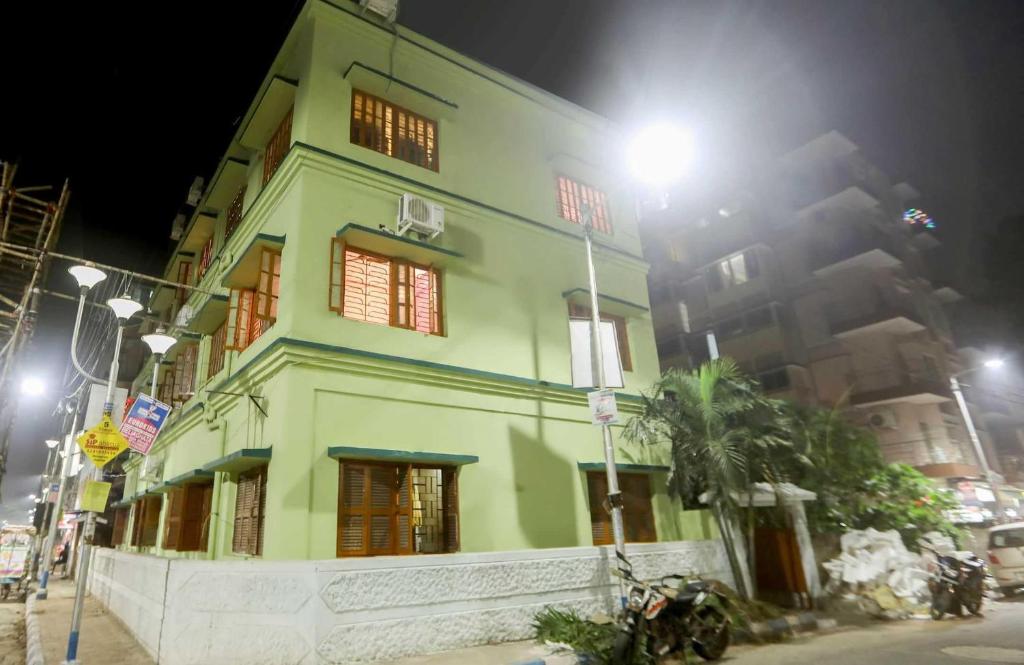 un edificio verde por la noche con luz de la calle en OYO Flagship PG Guest House, en Tangra