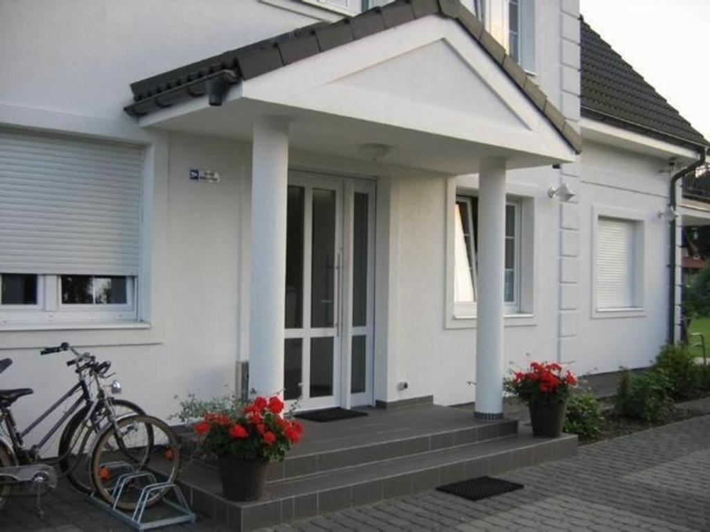 a white house with a bike parked in front of it at Gemütliche Wohnung in Rowy mit Terrasse, Grill, Parkplatz und Garten in Rowy