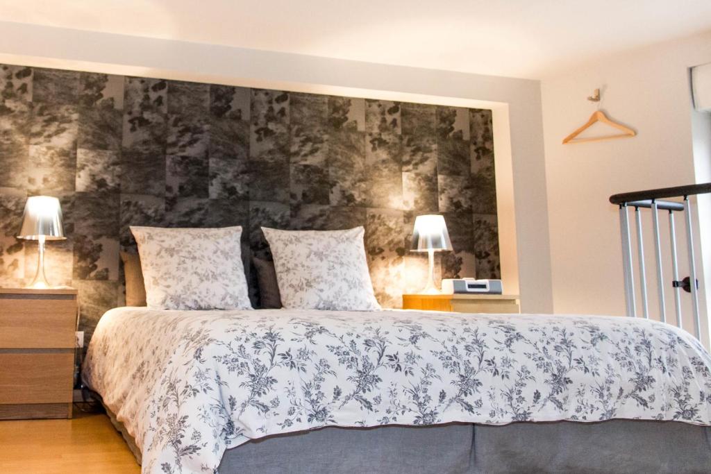 une chambre avec un grand lit et deux lampes dans l'établissement La Noctambulle Cathédrale, à Reims