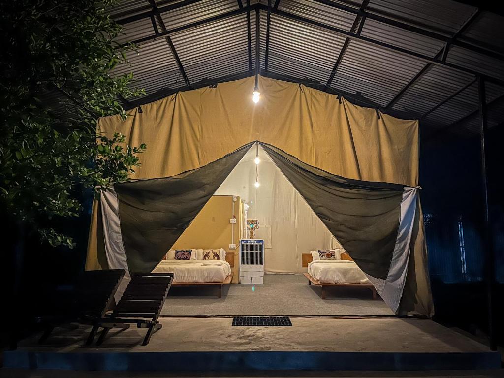 Zelt in einem Schlafzimmer mit 2 Betten in der Unterkunft Glampin By Tharu Garden in Sauraha