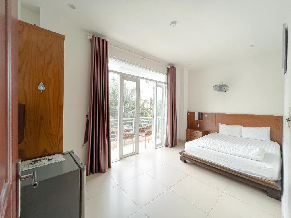 a bedroom with a bed and a large window at Sunny Motel Tuần Châu in Ha Long