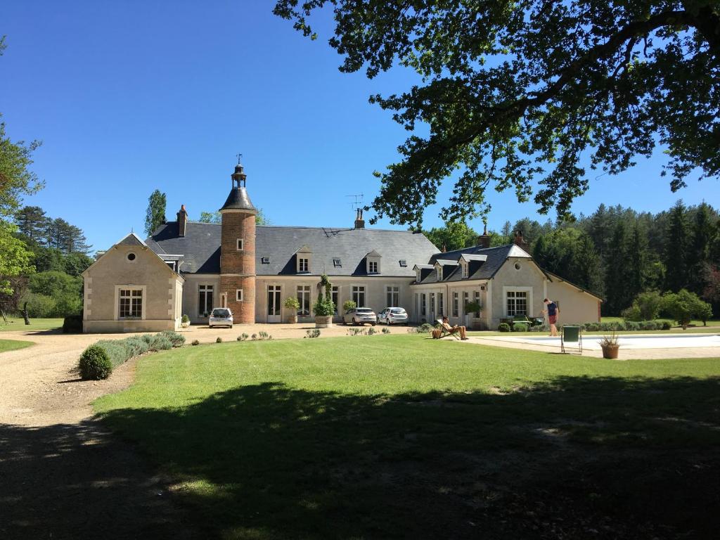 una casa grande con un patio de hierba delante de ella en Domaine de charme - Les Places en Lassay-sur-Croisne