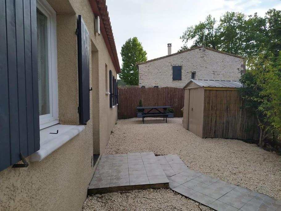 a backyard with a bench and a fence at Villa 200m2, 3 suites, patio avec salle jeux, 1 piscine CHAUFFE DE DEBUT AVRIL A FIN OCTOBRE in Maruéjols