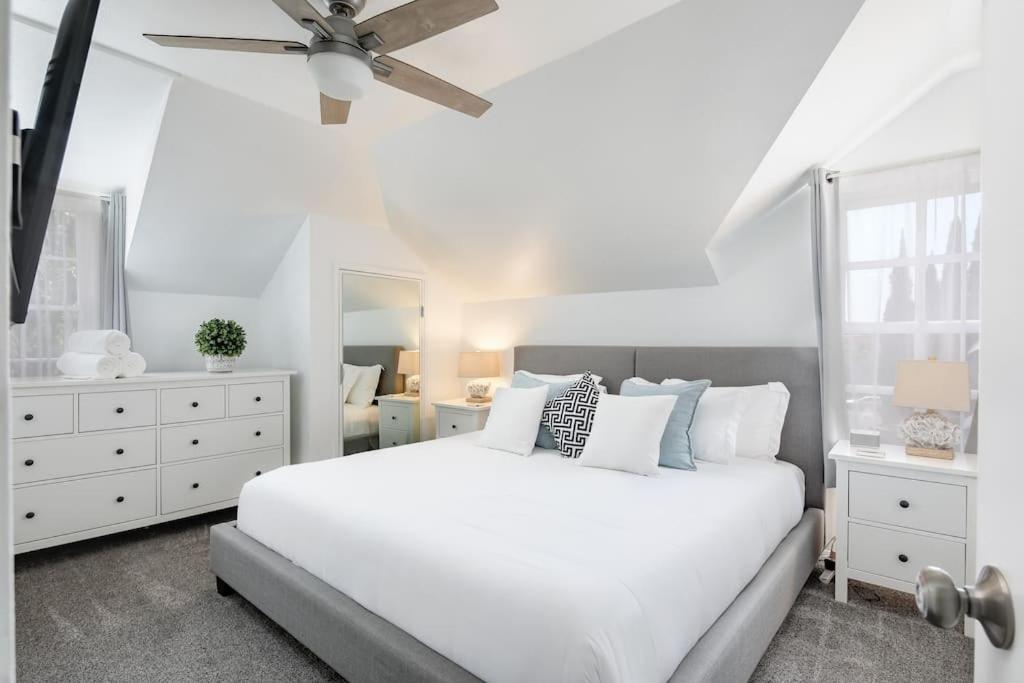 a white bedroom with a white bed and a ceiling fan at 3 Bedroom 2 Bath House with Parking - 10 Guests in San Diego