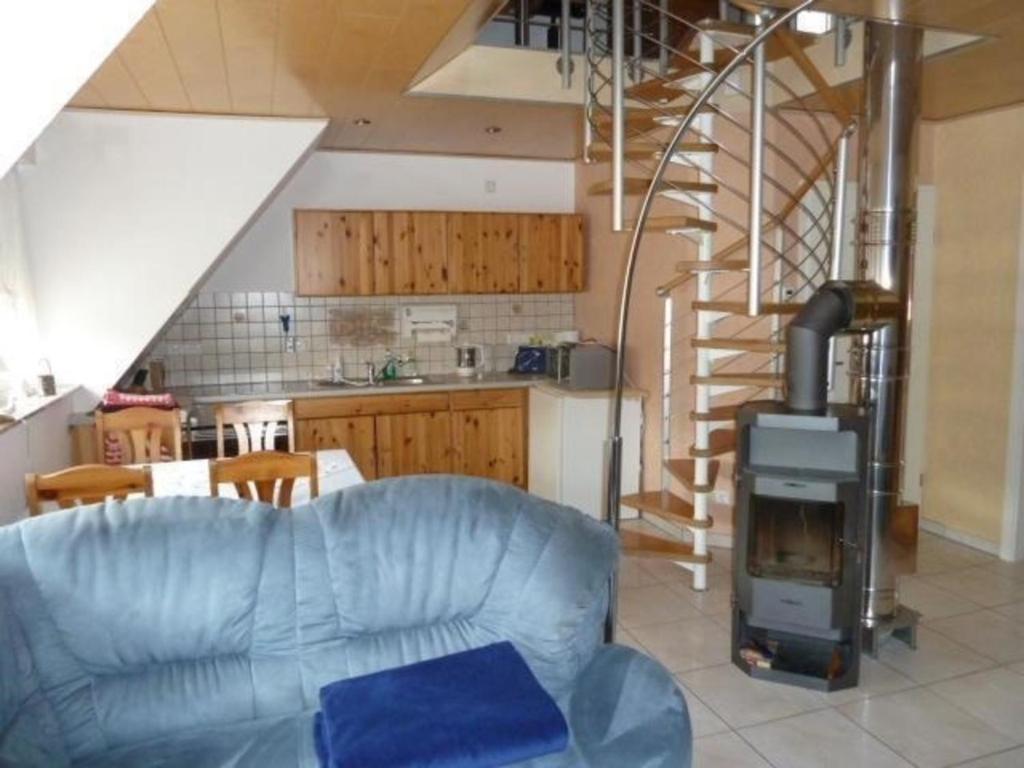 sala de estar con sofá azul y chimenea en Ferienwohnung auf zwei Etagen, inmitten herrlicher Landschaft - b48738, en Pretzfeld