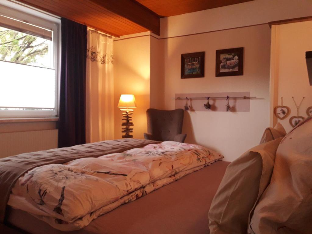 a bedroom with a bed and a chair and a window at Traumapartment Pöstlingberg, reservierter Parkplatz, 4 Schlafzimmer in Linz